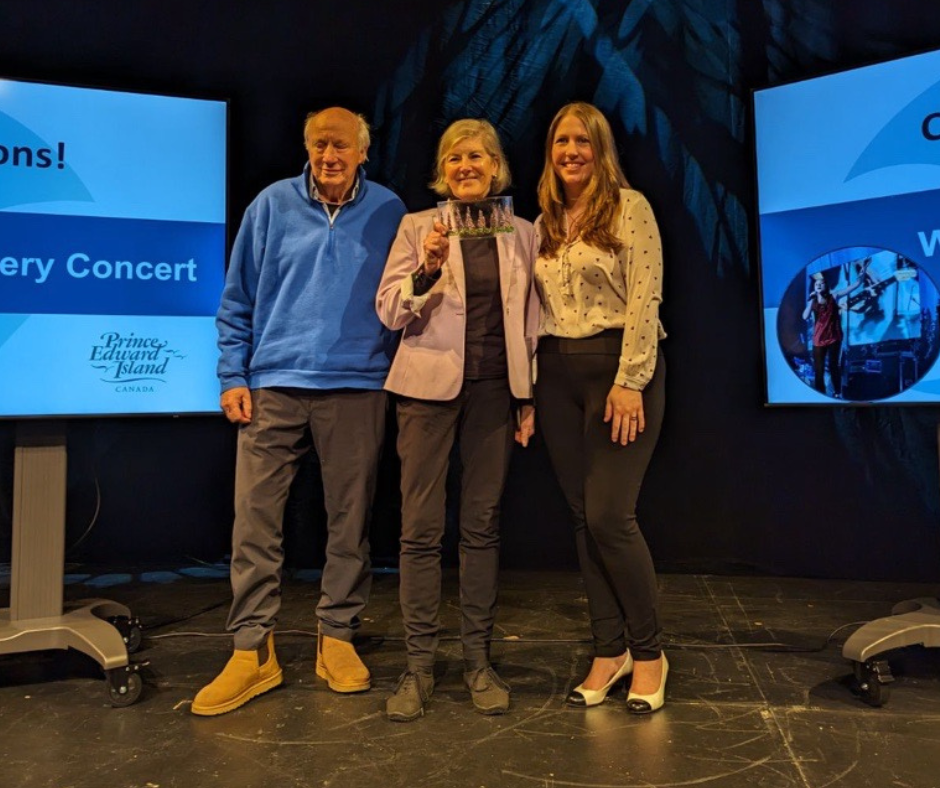 Fiona and Brooks Diamond stand onstage accepting an award