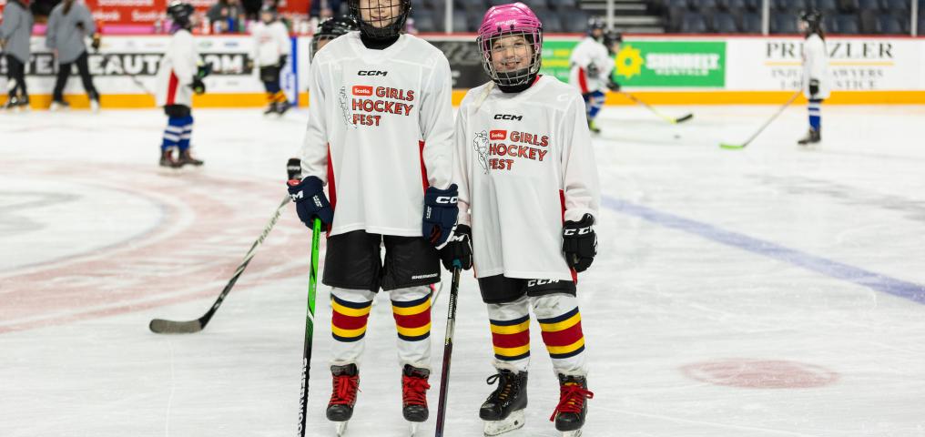 Girls pose on ice with gear