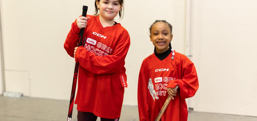 Two participants hold sticks