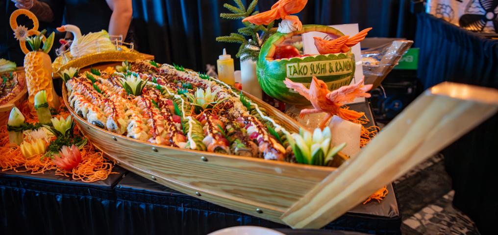 A decorative placement of appetizers with a melon that has Savour etched into the surface
