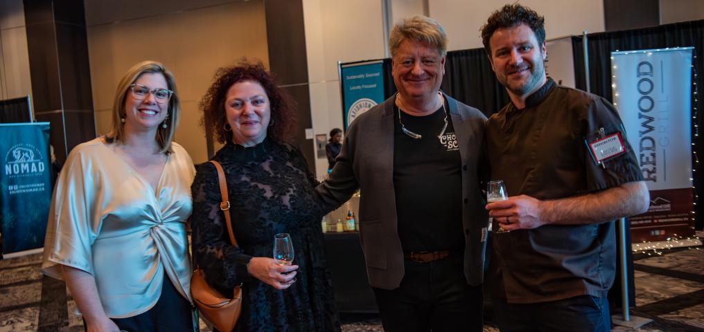 Four guests stand side-by-side at Savour smiling at the camera