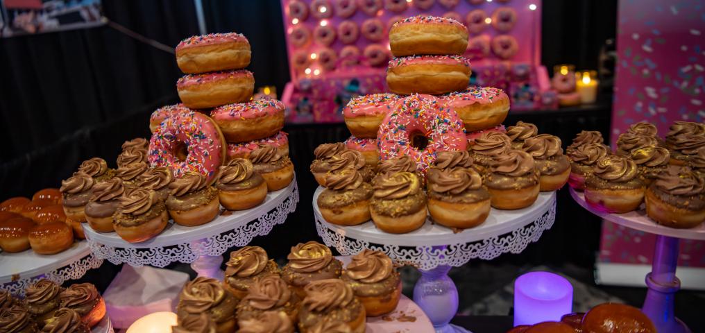 A food display shows a stack of donuts and delicately decorated pastries