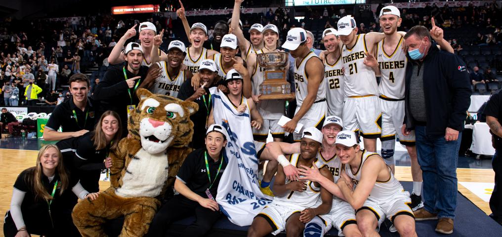 the 2022 AUS basketball champions, the dalhousie men's team, is shown holding the champion banner
