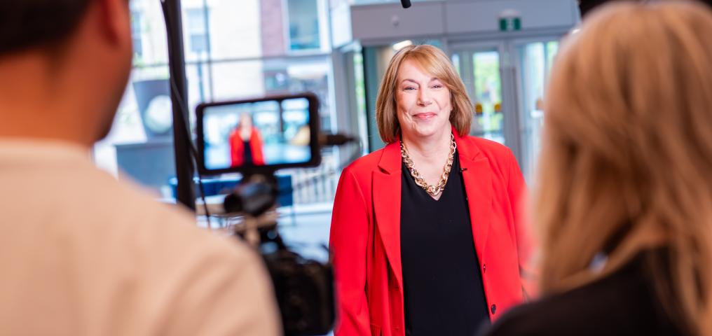 President & CEO Carrie Cussons stands in front of the camera prepping to filman interview