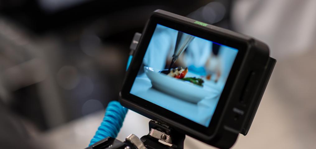 A camera screen is shown capturing activities in the convention centre kitchen