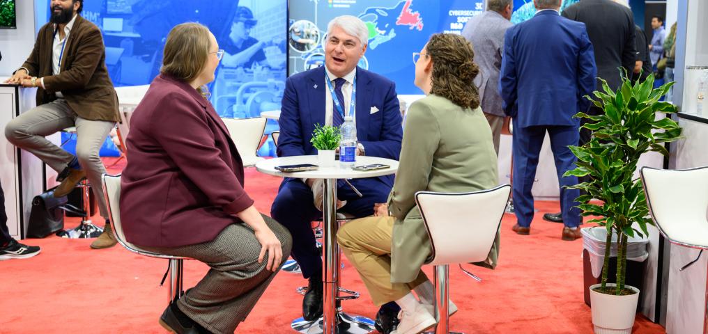 A group of delegates sit at a bistro table in the conference room